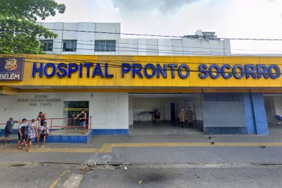 Foto da fachada do Hospital Pronto-Socorro Municipal Mário Pinotti, em Belém (PA). A entrada do hospital é coberta por uma grande marquise amarela onde se lê "Hospital Pronto-Socorro" em letras azuis. Há várias pessoas na calçada e na rampa de acesso.