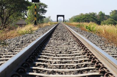 Foto mostra trecho de ferrovia, com vegetação nas margens