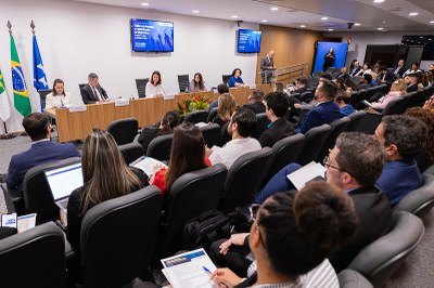 Imagem do auditório do seminário com a mesa de abertura em que as autoridades estão sentadas e os participantes na plateia