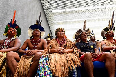 Foto ilustrativa: Gustavo Lima/STJ A imagem mostra um grupo de indígenas sentadas em um ambiente fechado. Elas vestem trajes tradicionais, com cocares coloridos e adornos de penas, colares e saias de palha. Algumas pessoas também usam roupas comuns, como camisetas.