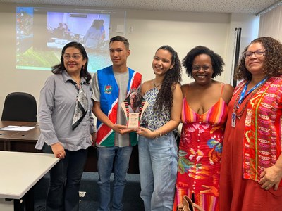 Imagem dos membros presentes em fotografia conjunta, segurando o troféu