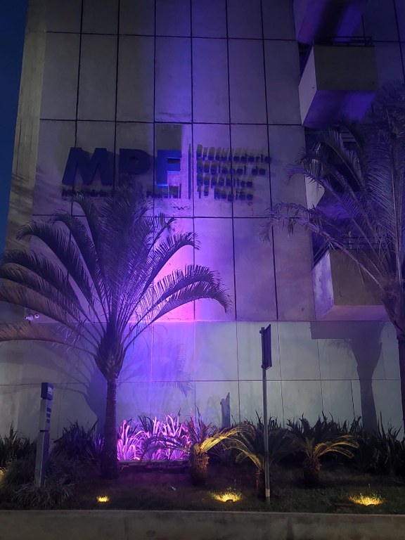 Prédio da PRR1 com iluminação lilás.