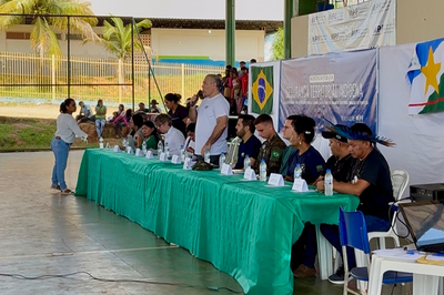Foto mostra mesa de autoridades em audiência pública realizada em quadra poliesportiva
