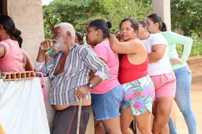 Membros da comunidade encostados em batente, em fila.