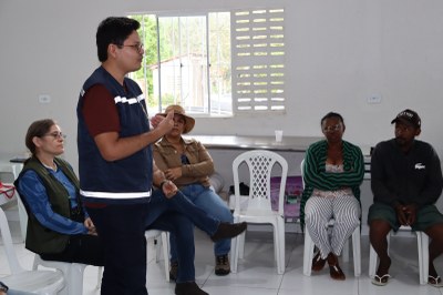 Equipe do MPF numa sala com cadeiras de plástico conversando com a comunidade