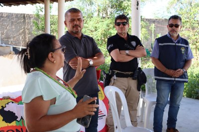 Uma mulher fala com três membros do MPF
