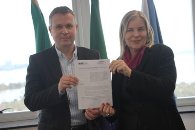 Procurador-chefe do MPF/RS Felipe Müller e a procuradora-chefe da Procuradoria Regional do Trabalho da 4ª Região (PRT4), Denise Maria Schellenberger Fernandes, seguram diante de si o documento assinado do protocolo de intenções para a construção de uma sede conjunta no município de Santo Ângelo