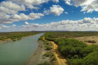 foto de vista aérea do rio são francisco, com árvores e plantas ao lado direito e um céu azul com nuvens brancas