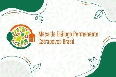 A imagem apresenta a identidade visual da Mesa de Diálogo Permanente Catrapovos Brasil. No lado esquerdo, há um logotipo com elementos que remetem à alimentação e diversidade: um prato colorido com desenhos de folhas, grãos e sementes, acompanhado de talheres — uma colher verde à esquerda e um garfo laranja à direita. O prato é parcialmente contornado por um arco laranja.

À direita do logotipo, está o nome “Mesa de Diálogo Permanente Catrapovos Brasil” em fonte fina e na cor laranja. O fundo da imagem é branco com discretas folhas em tom claro e contornos orgânicos em verde escuro nas bordas, acompanhados de desenhos de folhas e linhas curvas, reforçando a ideia de natureza e coletividade.