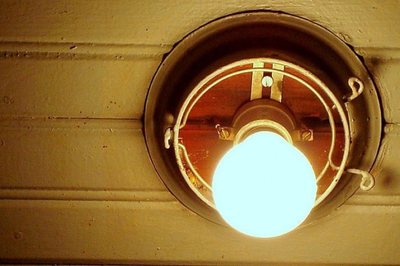 Imagem: EBC Lâmpada acesa em um teto de madeira. O foco está no brilho da luz, indicando um ambiente interno iluminado.
