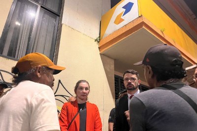 Juíza federal e procurador regional dos Direitos do Cidadão no Pará entrevistam representantes da sociedade civil durante inspeção judicial. Foto: Comunicação/MPF. Quatro pessoas conversam em frente a uma agência dos Correios. Há dois homens de boné, de costas, e uma mulher de casaco e um homem de terno e óculos.