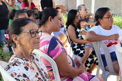 Foto lateral com membros da comunidade em plano de foco.