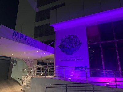 foto da fachada do prédio do MPF em Cuiabá com iluminação lilás
