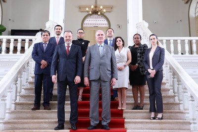 Foto oficial com autoridades em pé sobre uma escadaria