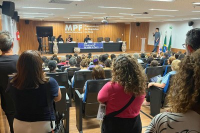 Escuta pública sobre privatização da saúde no Pará, na sede do MPF, em Belem (PA), em 22/10/2025. Foto: Comunicação/MPF. Vista de auditório lotado, de costas para a câmera, com painel ao fundo: "MPF - Ministério Público Federal - Procuradoria da República no Pará" e faixa "Escuta Pública - Privatização da Saúde no Pará" com pessoas sentadas e outras no palco e púlpito.