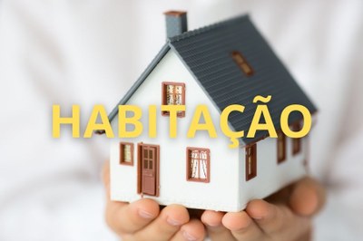 Arte: Comunicação/MPF. Fotografia das mãos de uma pessoa segurando uma casa de brinquedo, com a palavra "habitação" sobrepondo a imagem, na cor amarela e em caixa alta.