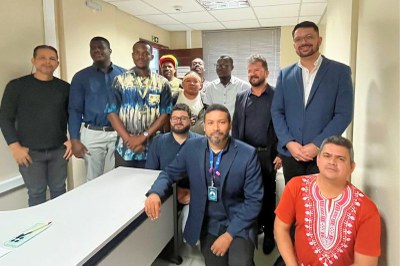 Fotos: MPF Um grupo de doze homens, em pé e sentados, posa para uma foto em um ambiente de escritório, com uma mesa branca à frente.