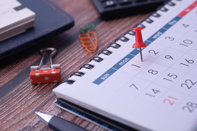 Foto: Banco de imagens Canva A imagem é uma fotografia de um calendário com um pin vermelho fixado em uma das datas.