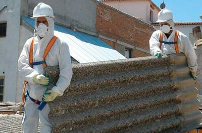 image-6.jpeg Foto de trabalhadores com roupa de segurança enquanto carregam telhas de amianto