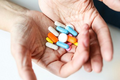 Foto: Polina Tankilevitch em pexels.com Duas mãos juntas seguram comprimidos de cores variadas.