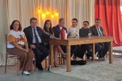 ASCOM Imagem 1 - Um grupo de seis pessoas sorridentes, três homens e três mulheres, posa perto de um grande corpo d'água sob um céu nublado.
Imagem 2 - Uma foto de sete pessoas sentadas em uma mesa de madeira rústica, dispostas em fila e olhando para a frente.