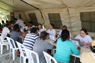 Fotos: Comunicação MPF Pessoas, incluindo a população de rua, em atendimento social e legal em mesas de campanha ao ar livre.