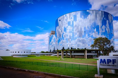 Foto dos prédio espelhados da Procuradoria-Geral da República (PGR). Ao fundo, o céu está azul entre nuvens!