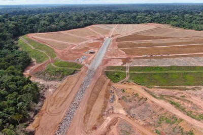 image11.jpeg Fotografia aérea de uma barragem de dejeitos desativada, com uma grande área ao centro de barro, floresta ao redor e uma estrada com poucos carros