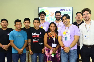 Grupo de dez pessoas em frente a uma tela com o texto "MPF na COP30", incluindo indígenas e não indígenas.