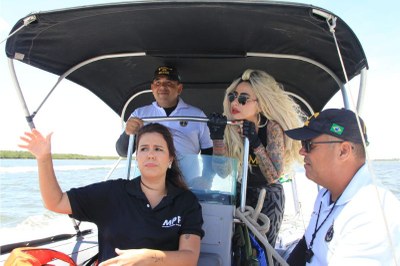 Foto mostra a procuradora e mais três pessoas durante a vistoria dentro de uma embarcação olhando para o rio