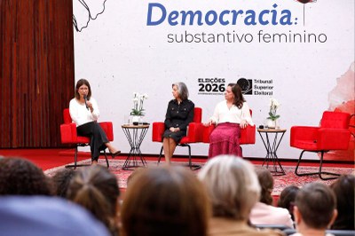 Foto: Alejandro Zambrana/Secom/TSE Imagem do palco do evento com as palestrantes sentadas em cadeiras e a plateia em frente