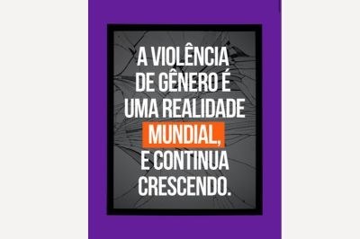 Imagem com fundo de vidro estilhaçado, moldura preta e borda roxa. Ao centro, em letras brancas, lê-se: “A VIOLÊNCIA DE GÊNERO É UMA REALIDADE MUNDIAL, E CONTINUA CRESCENDO.” O visual transmite impacto e urgência.