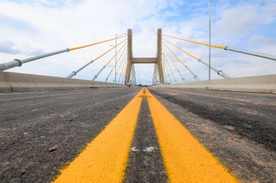 Ponte sobre o Rio Itacaiúnas, na inauguração, em 2024 /Foto: Marco Santos / Ag. Pará) Vista da perspectiva de uma ponte estaiada, com as duas faixas centrais amarelas da pista de asfalto em primeiro plano e as torres e cabos de sustentação amarelos e cinzas ao fundo, sob céu parcialmente nublado.