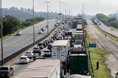 Foto mostra caminhões enfileirados em uma rodovia