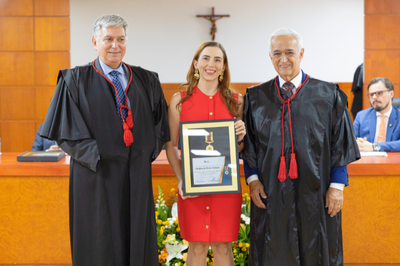 Foto: TRE/RO Foto mostra a procuradora-chefe Daniela Lopes de Faria ao centro, com vestido vermelho, com dois desembargadores de cada lado.