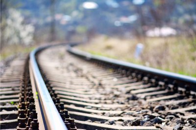 Trilho de trem com curva para a direita ao fundo