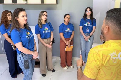 mulheres com camisetas do MPEduc escutam homem falar 