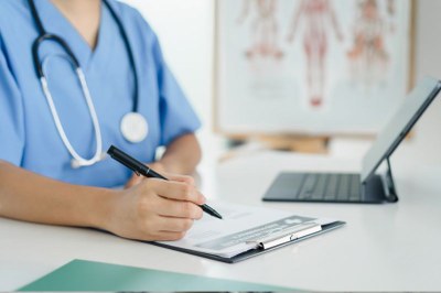 Foto: Canva Imagem de uma profissional em hospital preenchendo um papel em uma prancheta