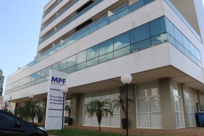 Fachada de um prédio moderno de vários andares, com janelas de vidro e placa com a sigla ‘MPF’ na entrada;