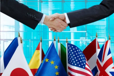 Imagem de um aperto de mão com bandeiras de diferentes países