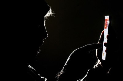 Imagem ilustrativa. Foto: Joédson Alves/Agência Brasil. Foto escura de um homem mexendo no celular