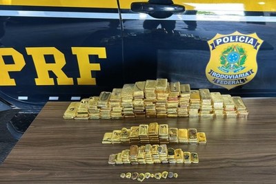 Foto: Polícia Rodoviária Federal (PRF). Foto mostra barras de ouro em cima do capô de um carro da PRF.