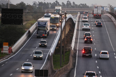 Foto: Marcos Porto/Prefeitura de Navegantes Foto mostra tráfego intenso de caminhões e carros em uma rodovia de pista dupla em uma ponte ou viaduto, ao entardecer.