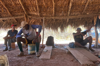 Trabalhadores sob uma cabana de palhoça