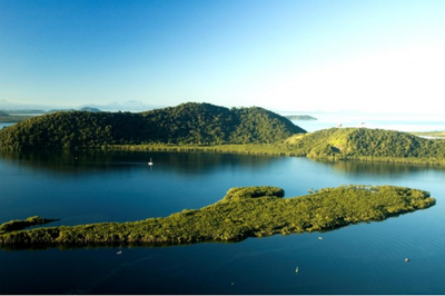 Vista aérea da baía de Paranaguá, com a Ilha da Cotinga coberta por vegetação nativa, cercada por águas calmas e outras ilhas da região.