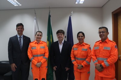 Foto: Ascom PR/MG Na foto, os cinco participantes posam lado a lado, com os três coronéis BM em laranja, uniforme do CBMMG, o tente-coronel de terno e o procurador da República ao centro, em traje social.